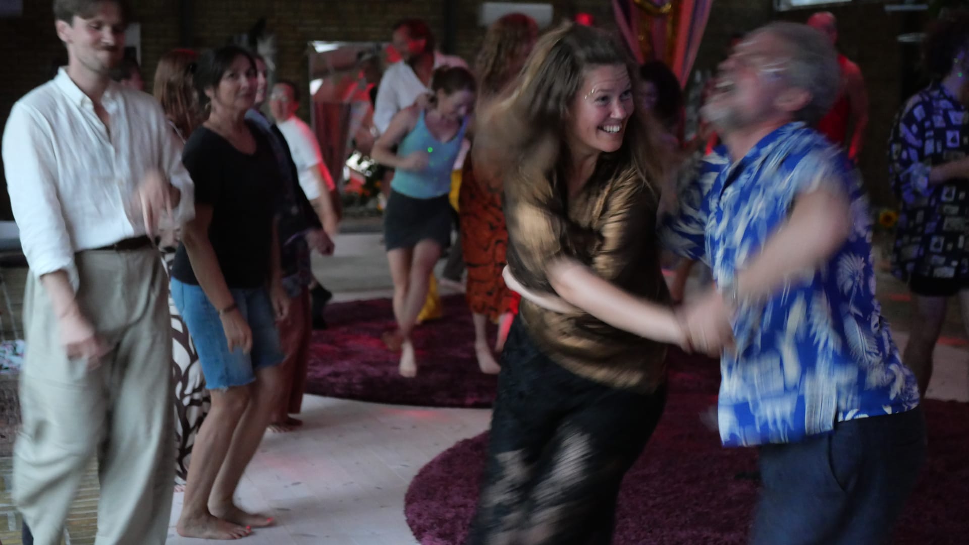 Two participants laughing as they dance together during the celebration evening