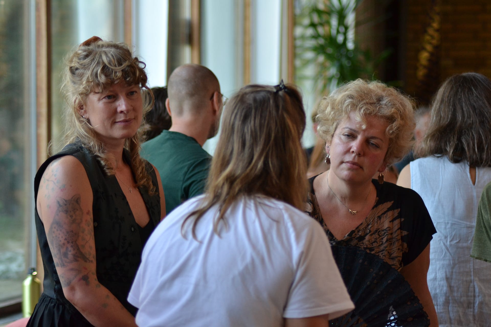Participants standing close together, listening to each other during a relational workshop